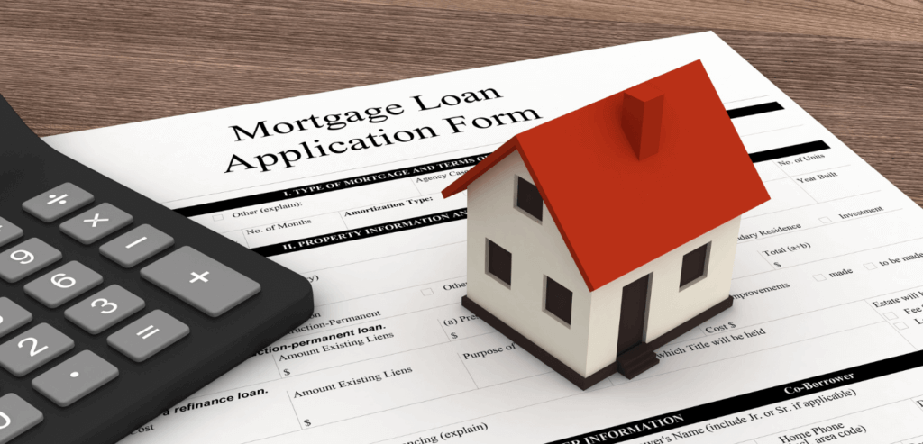 A picture of a miniature home sitting on top of a mortgage loan application form with a calculator to the left of the image.
