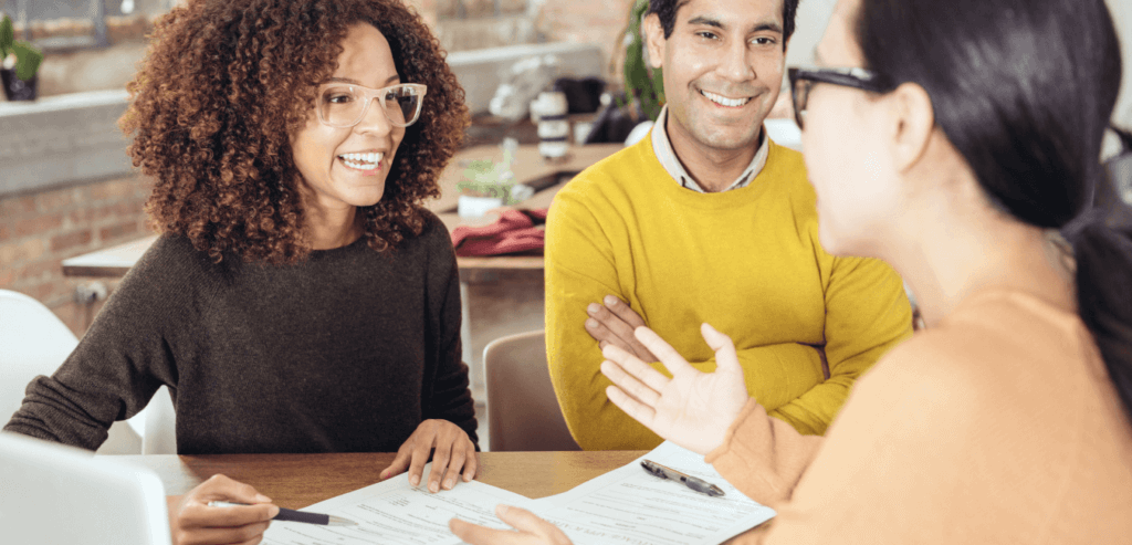 A picture of three people talking while sitting in front of papers.