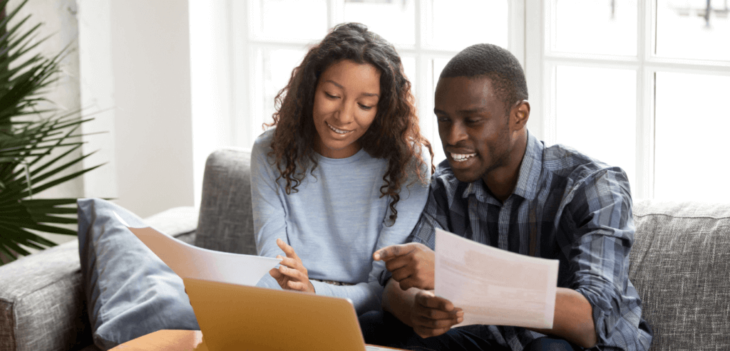 A picture of two people sitting down looking at papers.