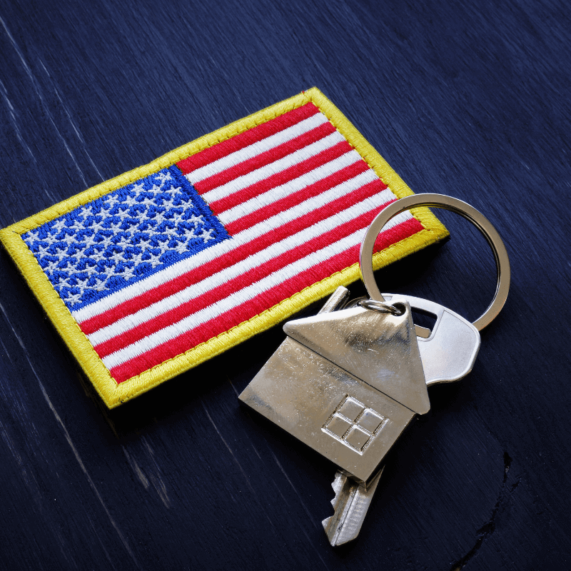 A picture of an American flag with a house key and house keyring.